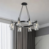 "A modern black brass chandelier with cone-shaped acrylic shades in a living room with curtains."