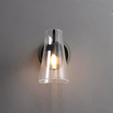 "A modern brass wall lamp with a clear acrylic shade on a gray wall."