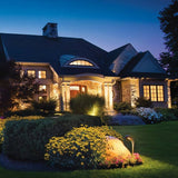 "Outdoor spotlights illuminating a house and garden at night, highlighting architectural and landscape features."