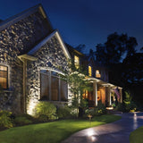 "Outdoor spotlights illuminating a house and pathway at night."