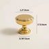 Gold cabinet knob with pedestal base shown with dimensions on beige background.