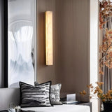 "The Emerson brass wall lamp illuminating a modern living room, showcasing its sleek design and warm, ambient glow."