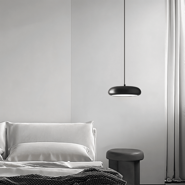 Single Emiva Pendant Light hanging beside a bed, providing soft ambient lighting for a modern bedroom setup.