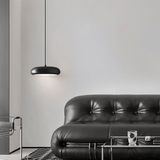 Emiva Pendant Light installed in a modern living room above a black leather sofa, enhancing minimalist interior aesthetics.