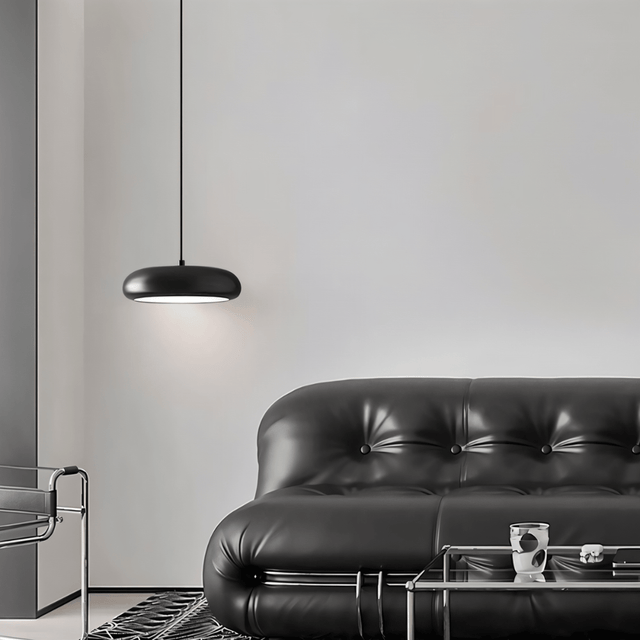 Emiva Pendant Light installed in a modern living room above a black leather sofa, enhancing minimalist interior aesthetics.