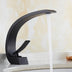 Black curved bathroom faucet with white spout displayed on a light marble countertop.