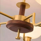 "Close-up detail of a brass and wood chandelier, showing the central wooden and brass components."
