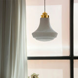 "Retro pendant light with a bell-shaped, striped glass shade and brass hardware hanging near a window, showcasing its vintage-inspired charm and soft, inviting glow."