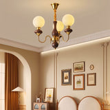 "Gold and dark wood Eurot chandelier with frosted glass globes hanging in a traditional living room."