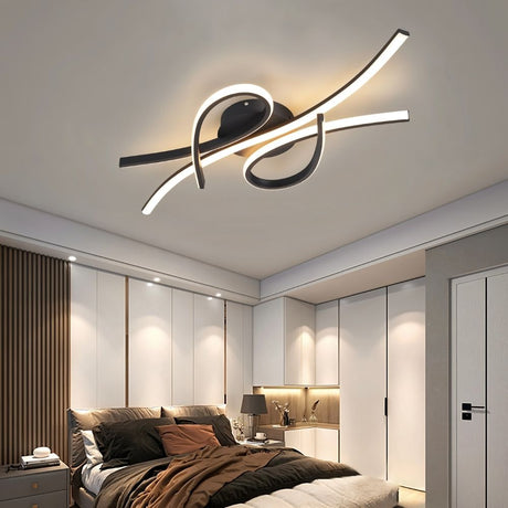 "A modern black ceiling light with intertwining LED bars installed in a contemporary bedroom with a large bed and closet."