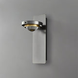 "A modern gunmetal wall lamp with an adjustable light and glass lens, shown against a gray background."