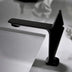 Black modern bathroom faucet with angular spout design on white sink counter.