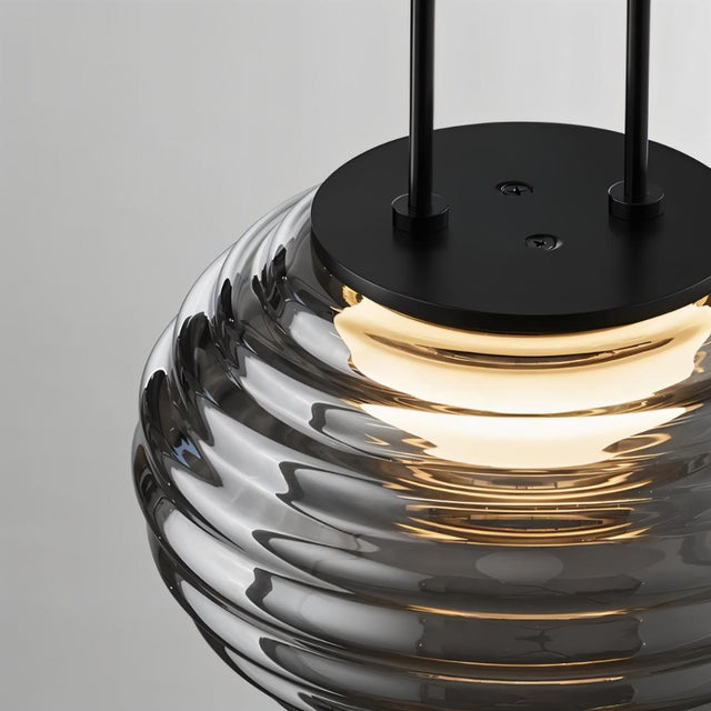 "Close-up of a smoky grey Filano pendant light showing the ribbed glass shade and black iron mounting."