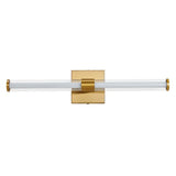 "A modern brass wall lamp with a clear glass tube shade, isolated on a white background."