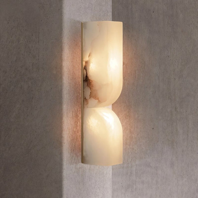 "A double curved alabaster wall lamp illuminating a corner with a soft, diffused light."