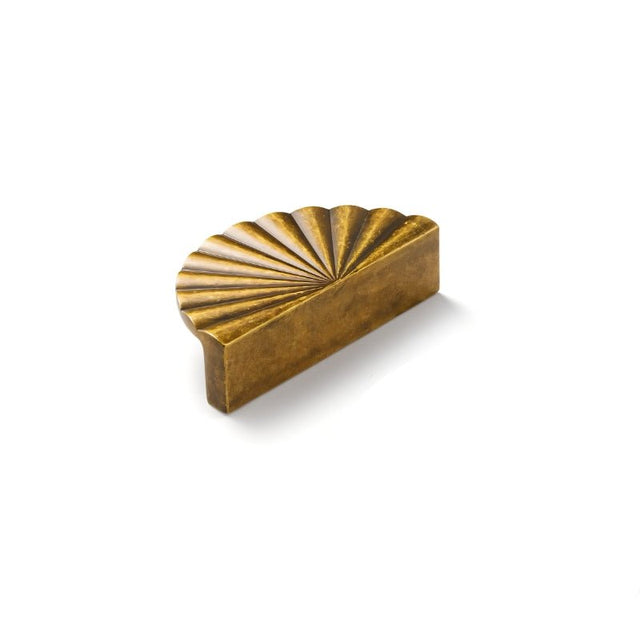 "A vintage brass fan-shaped drawer pull made of durable metal with a ridged, pleated surface and intricate grooves, in a half-moon Art Deco-inspired design."