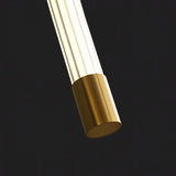 "Close-up of a modern wall lamp showing the brass end cap and acrylic diffuser, highlighting the materials and minimalist design."