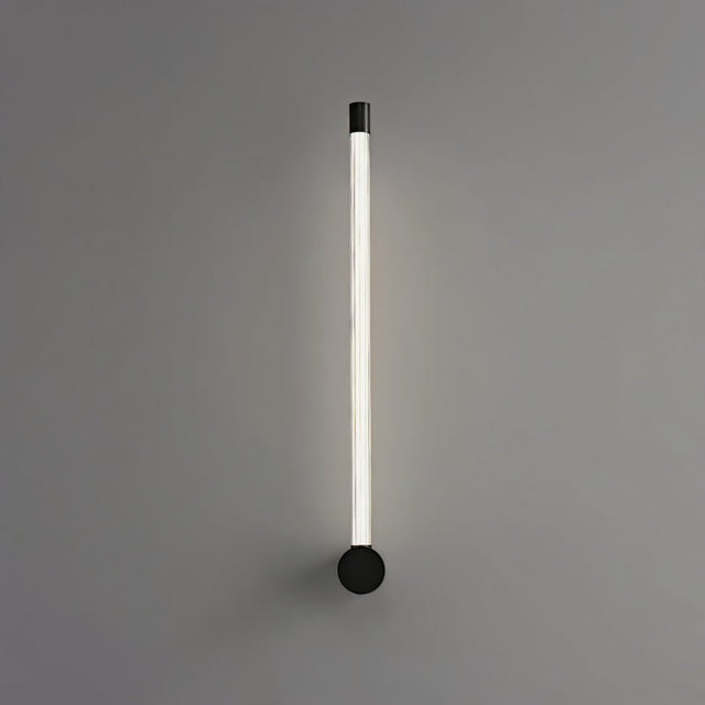 "A sleek, minimalist black wall lamp with a long, thin light bar and acrylic diffuser, mounted vertically on a gray wall."