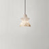Alabaster pendant light with star-shaped shade casting warm glow against neutral ceiling.