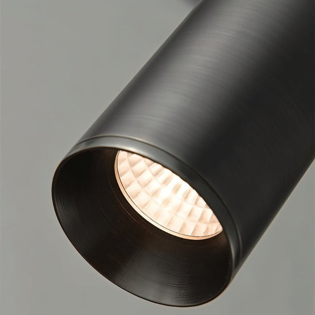 "Close-up of a sleek, cylindrical iron pendant light, showcasing its minimalist design and focused downward light."