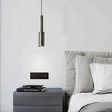 "Minimalist iron pendant light with a slender, cylindrical profile, providing focused downward illumination as a bedside reading light in a modern bedroom."