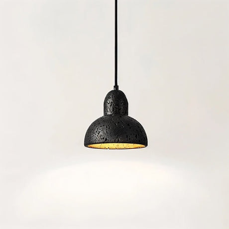 "A domed black travertine pendant light, isolated on a white background, showing the stone's texture and warm light."
