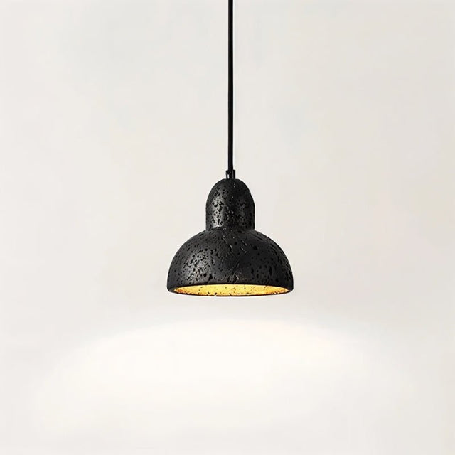 "A domed black travertine pendant light, isolated on a white background, showing the stone's texture and warm light."