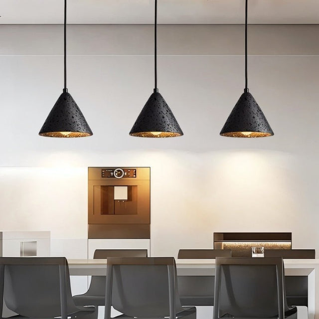 "Three conical black travertine pendant lights hanging above a kitchen island, providing warm lighting."
