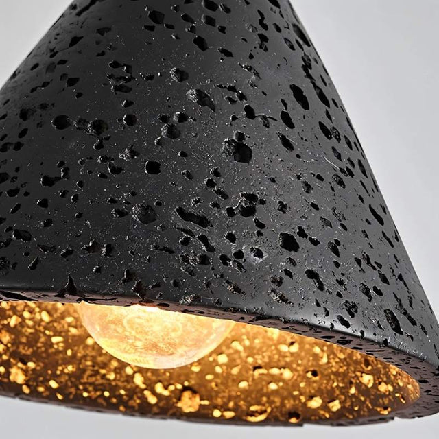 "A detailed close-up of a conical black travertine pendant light, showing the stone's texture and the warm light from the bulb."