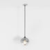 Pendant light with chrome dome shade and black cord suspended from ceiling against white background.