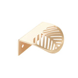 "A brushed gold leaf-shaped drawer pull isolated on a white background."