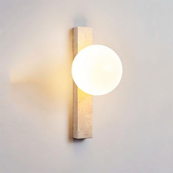 "Elegant travertine wall lamps with frosted glass globes mounted in a contemporary bedroom"