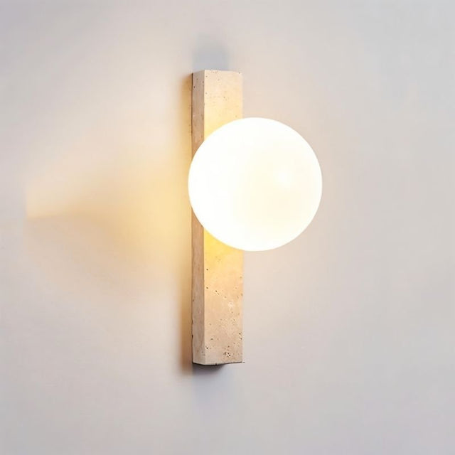 "Elegant travertine wall lamps with frosted glass globes mounted in a contemporary bedroom"