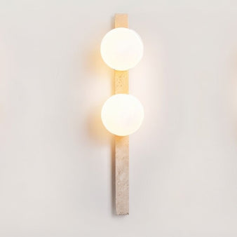 "Minimalist travertine wall lamp with two frosted glass globes mounted on a vertical stone base"