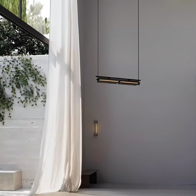 "Modern linear pendant light hanging near a window with sheer curtains, showing a minimalist interior."