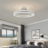 "A modern LED ceiling light with interlocking white rings, illuminating a bright bedroom with a city view."