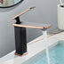 Modern bathroom faucet with black body and rose gold accents mounted on white sink basin with running water.