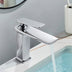 Modern chrome single-handle bathroom faucet with waterfall spout installed on sink basin with running water.