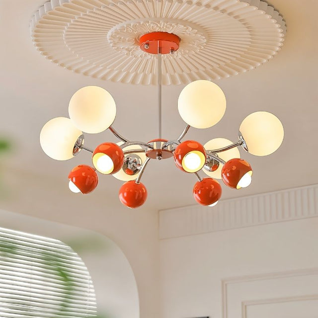 "An 8-light mid-century modern chandelier with red and white acrylic globe diffusers, hanging from a decorative ceiling."