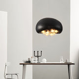 "black resin pendant light with glowing globes, minimalist dining setup, modern lighting fixture"