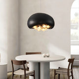 "black resin dome pendant light with illuminated globes, minimalist round dining table setup, modern decor"
