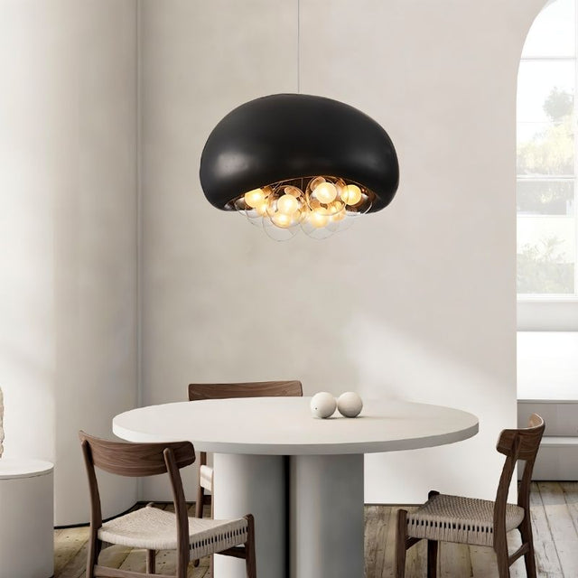 "black resin dome pendant light with illuminated globes, minimalist round dining table setup, modern decor"
