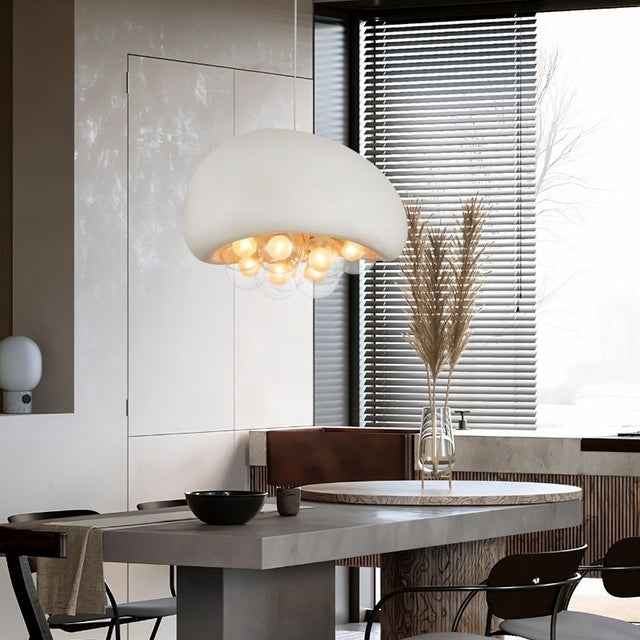 "white resin pendant light with glowing globes, contemporary dining setup, earthy decor, and natural lighting"
