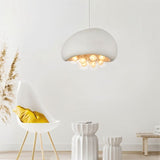 "white resin dome pendant light with glowing globes, modern minimalist decor, accent chair, and neutral tones"