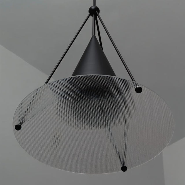 "Close-up of a modern black pendant light with a cone shade and textured glass disc."