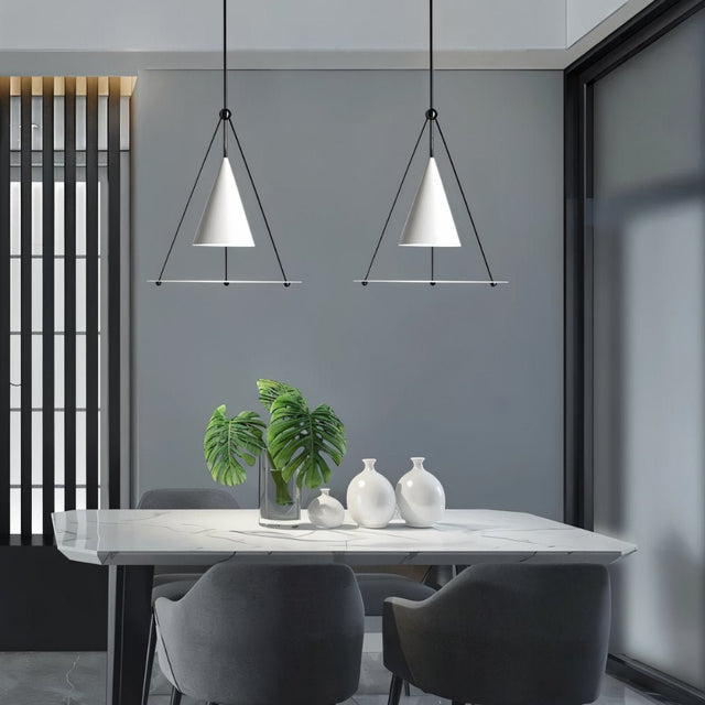 "Two modern white pendant lights with cone shades and frosted glass discs above a dining table."