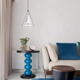 "A modern white pendant light with a cone shade and frosted glass disc in a living room with a blue table and sofa."