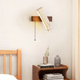"A modern wall lamp with an angled yellow travertine shade and a rectangular wooden base, casting a warm, ambient light in a bedroom setting."