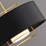 "Close-up of the black fabric shade and gold frame of a pendant light."