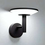 "A modern, circular LED outdoor wall lamp emitting a bright, white light on a light gray wall."